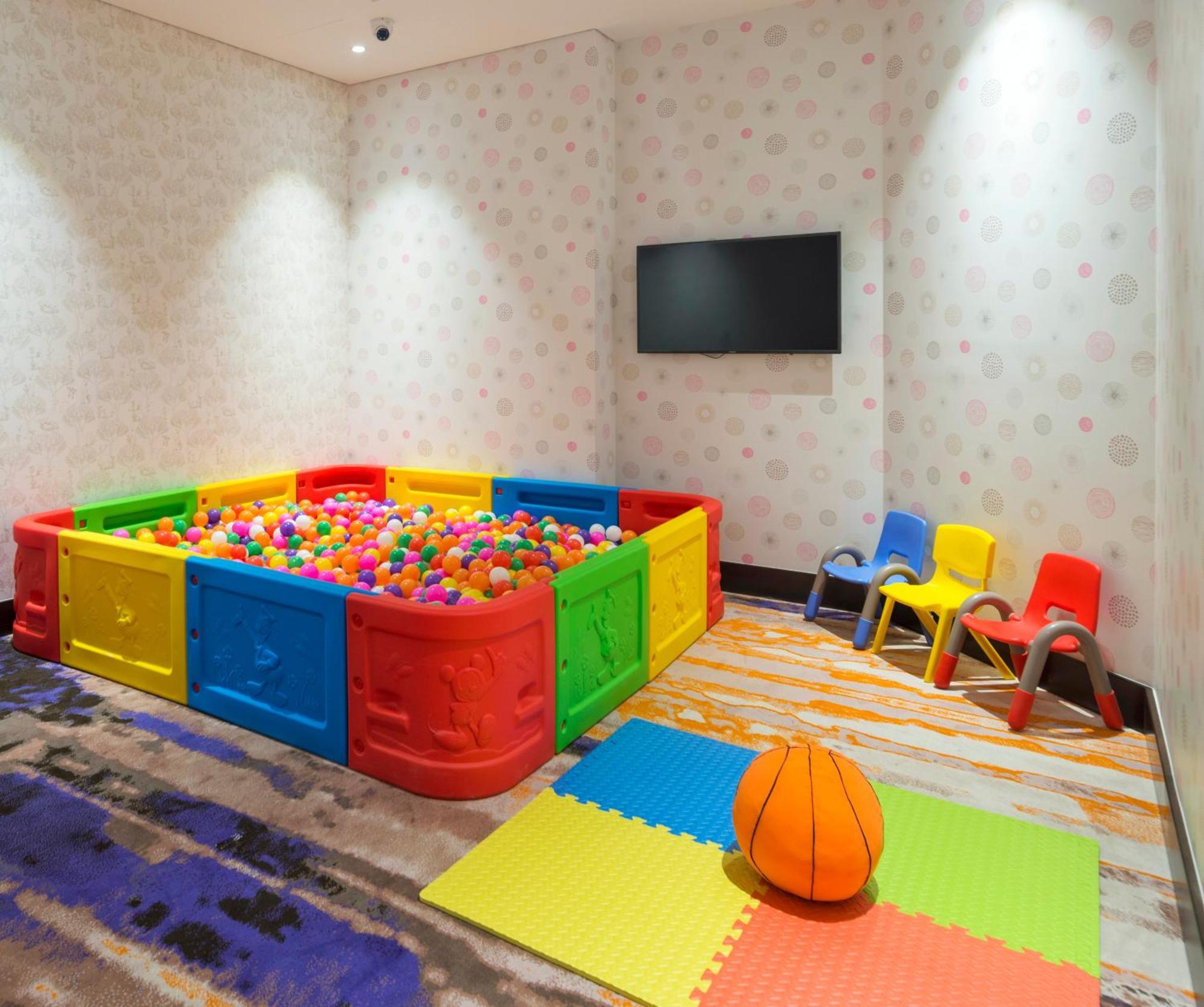 Canal Central Hotel Business Bay Dubaj Zewnętrze zdjęcie The photo shows a colorful children's play area. It features a large ball pit surrounded by bright, plastic walls in red, yellow, and green. The ball pit is filled with numerous multicolored plastic balls. Nearby, there are several small, brightly co
